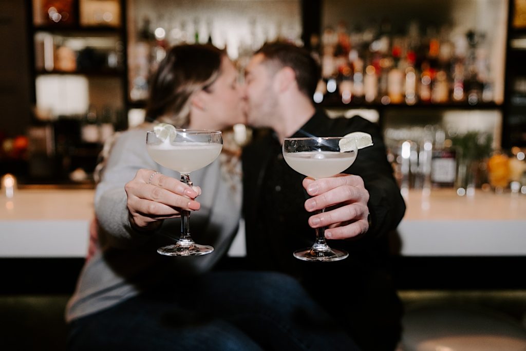 Engaged couple shares margaritas and kiss 