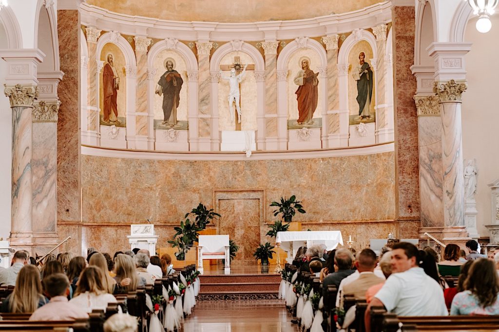 Straight down the aisle inside ornate church in Indiana wedding