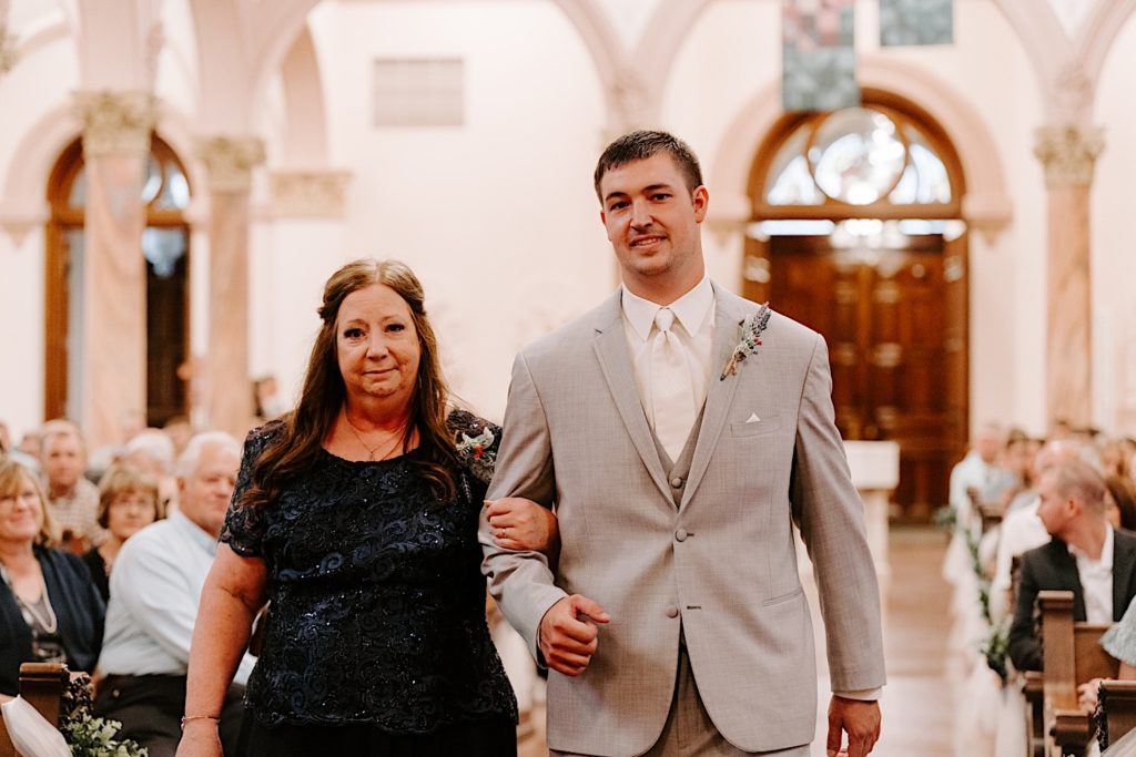 Groom and mother walking down aisle in Indiana church