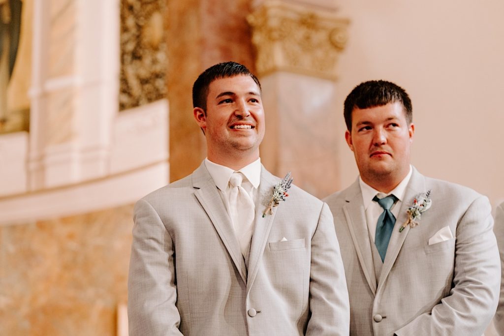 Groom at alter with best man in ornate Indiana church