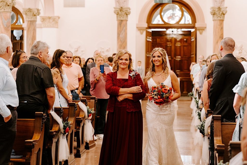 Bride walking down aisle escorted by mother in Indiana church