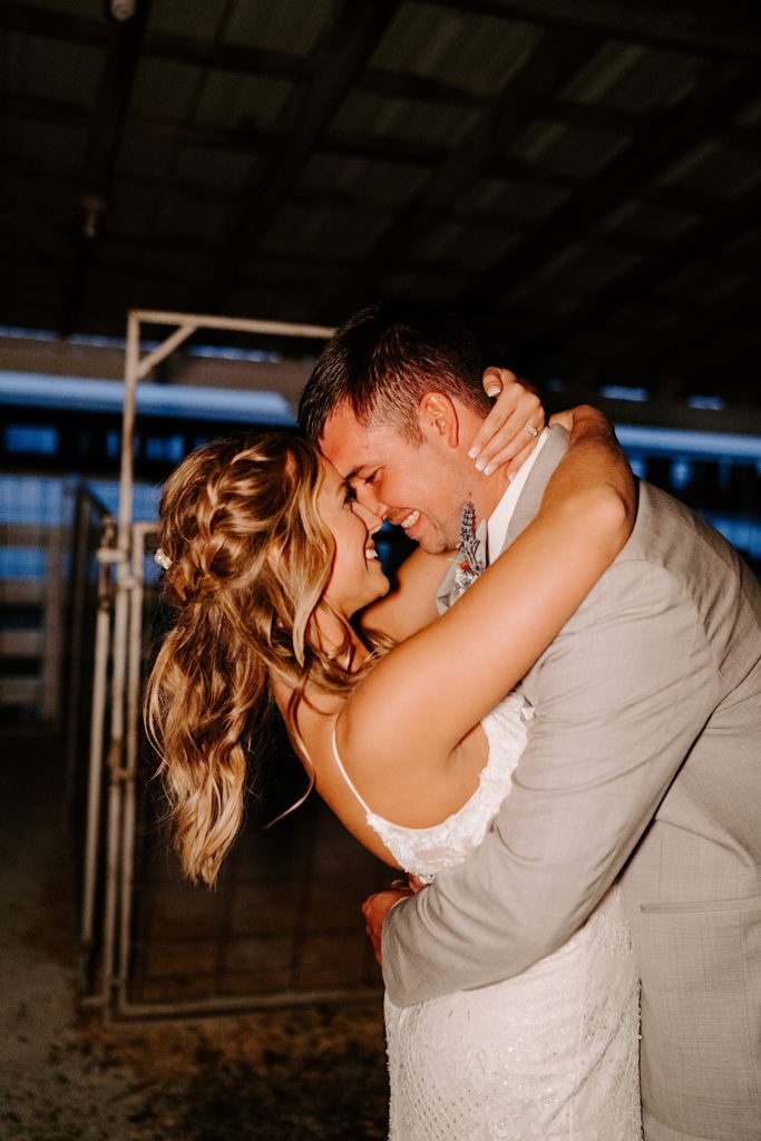 Newlyweds smiling and touching noses in embrace after reception ends