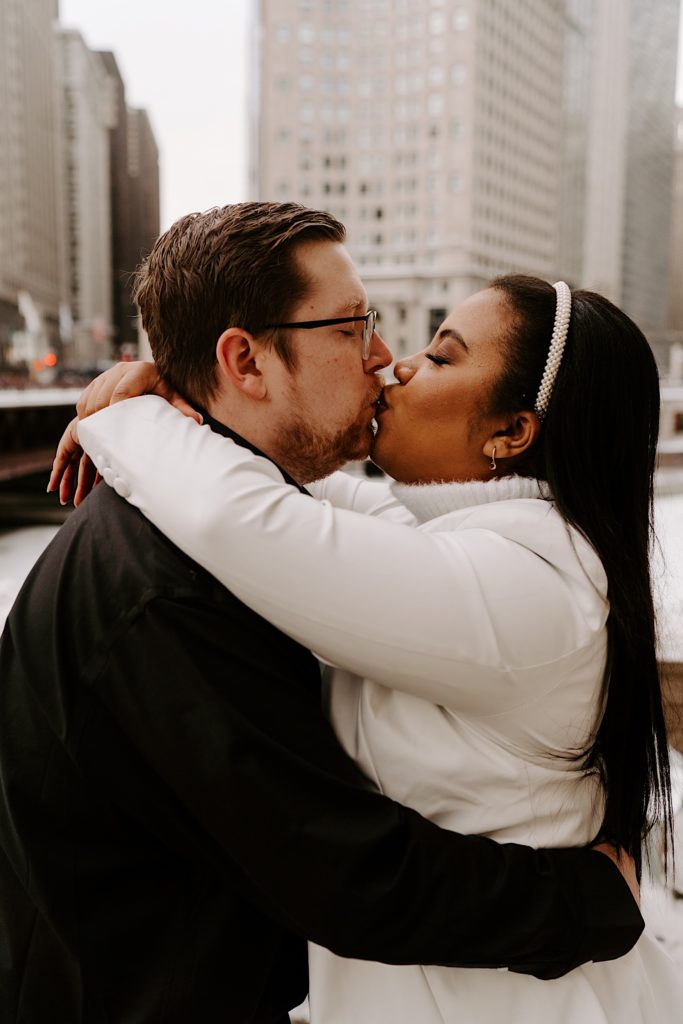 Engaged couple kissing on Chicago bridge