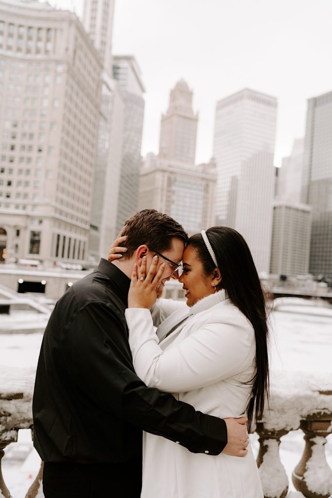 Engaged couple holding each other on Chicago bridge