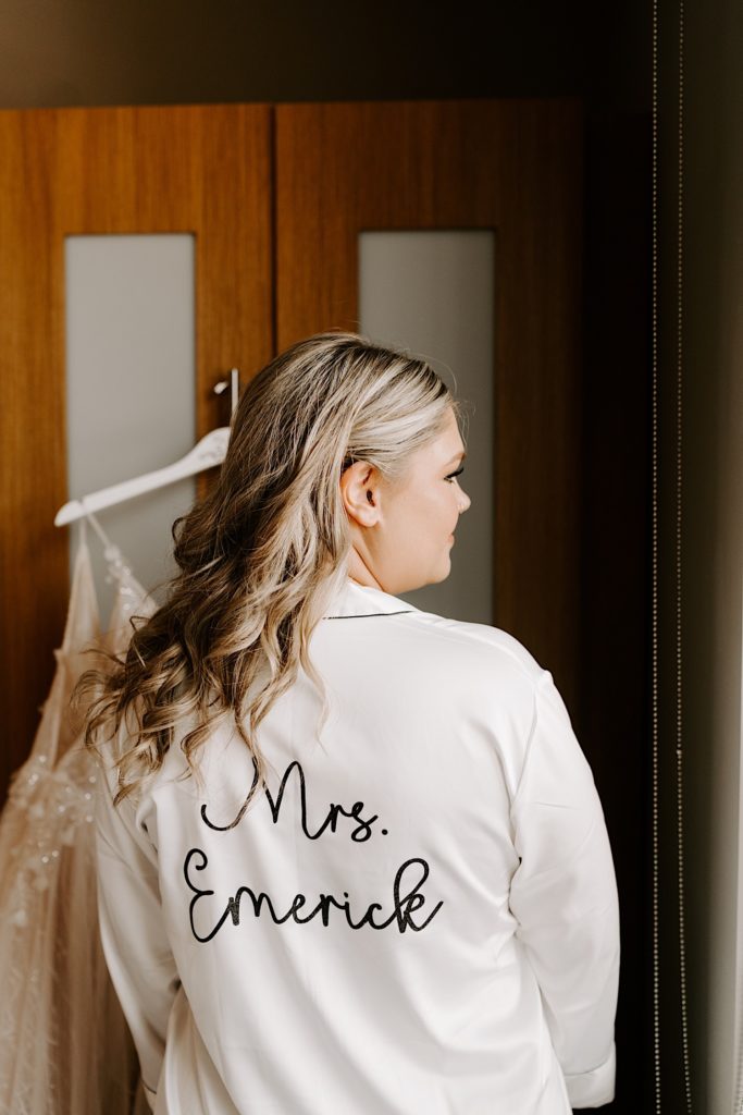 Bride wearing white bridal pajamas with her new last name on the back