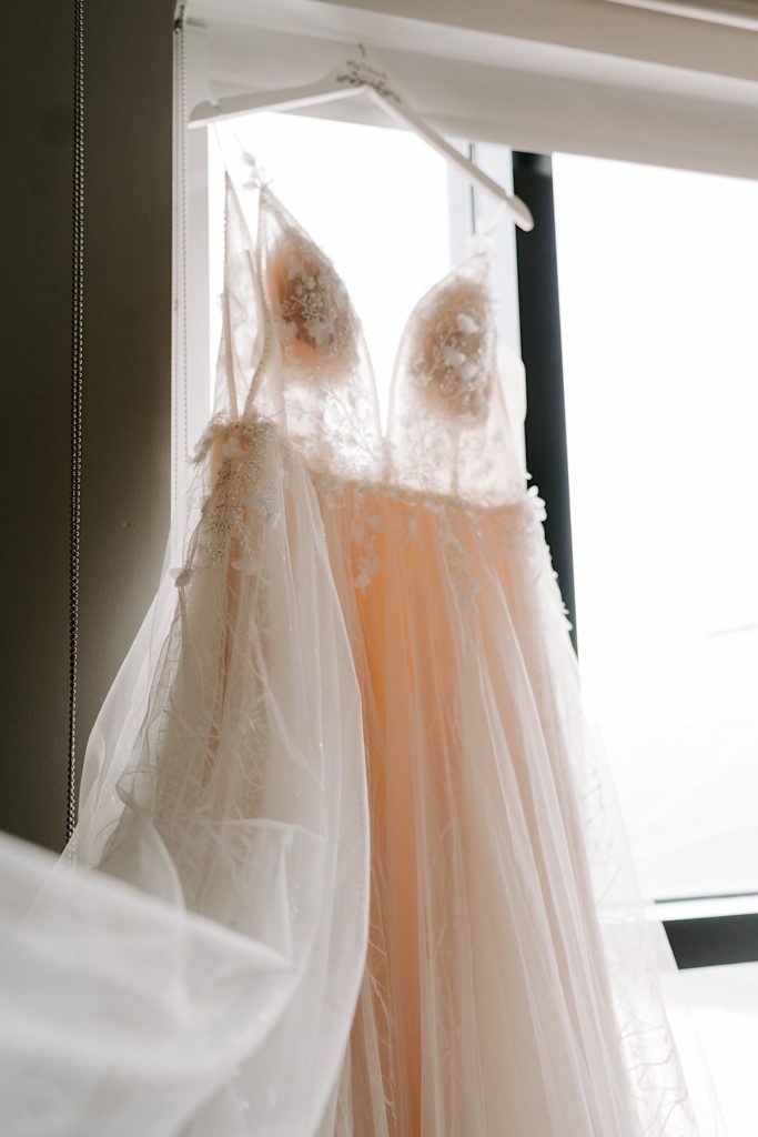 Wedding dress hung in front of window