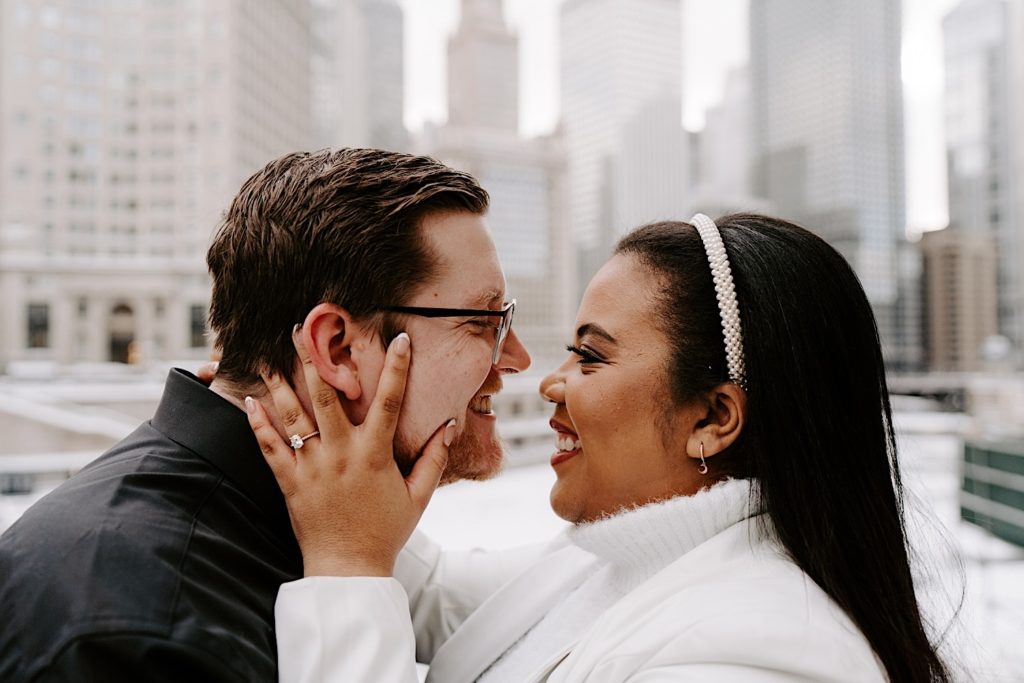 Engaged couple holding faces and looking into each others eye in Chicago winter engagement session