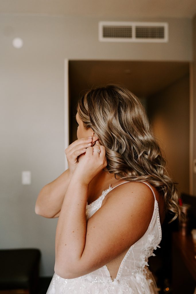 Bride putting her earrings on before wedding day