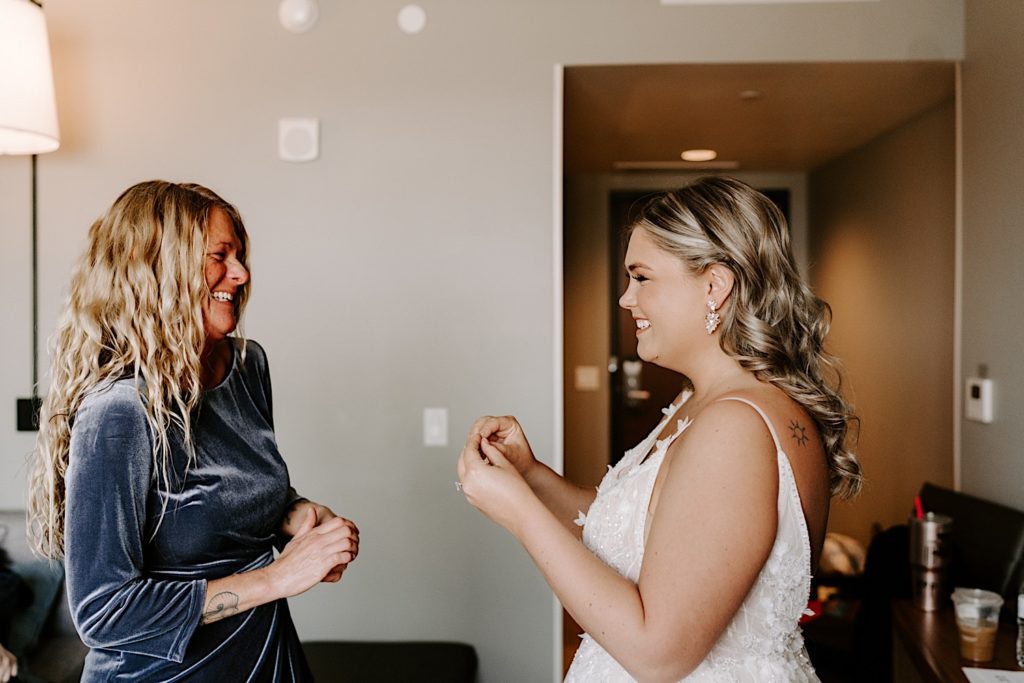 Bride with her mother laughing while getting ready for ceremony 