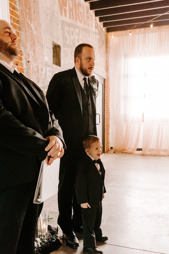 Groom and son standing at the altar waiting for bride