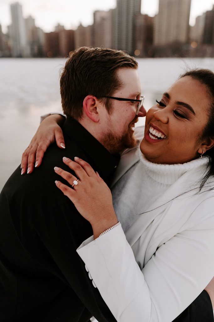 Engaged couple embraces on North Avenue beach in the winter