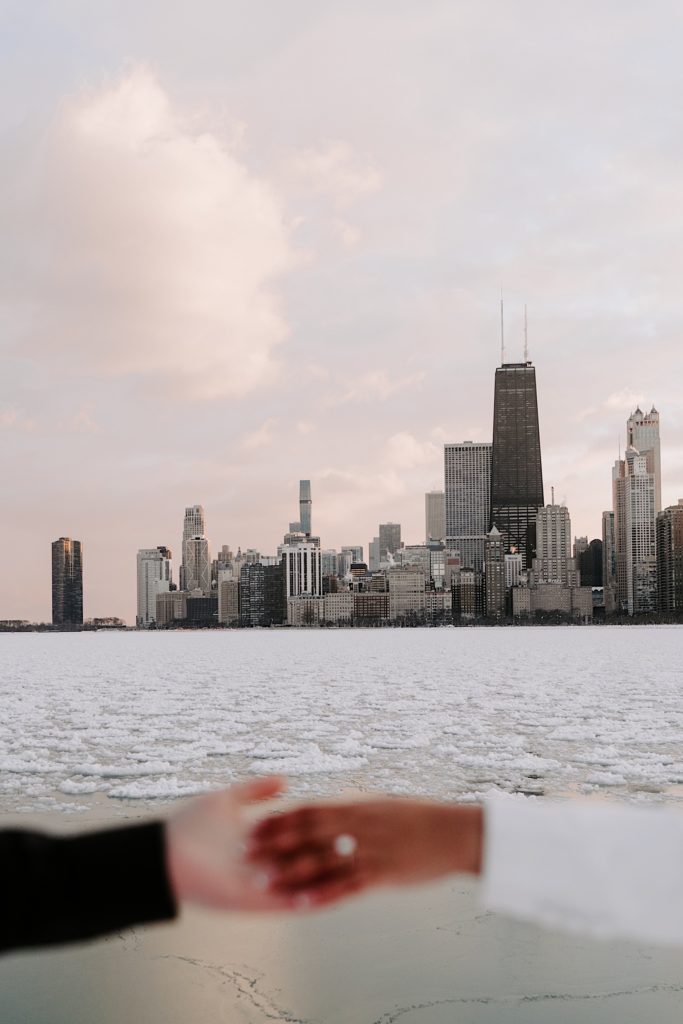 Engaged couples hands in front of the Chicago skyline