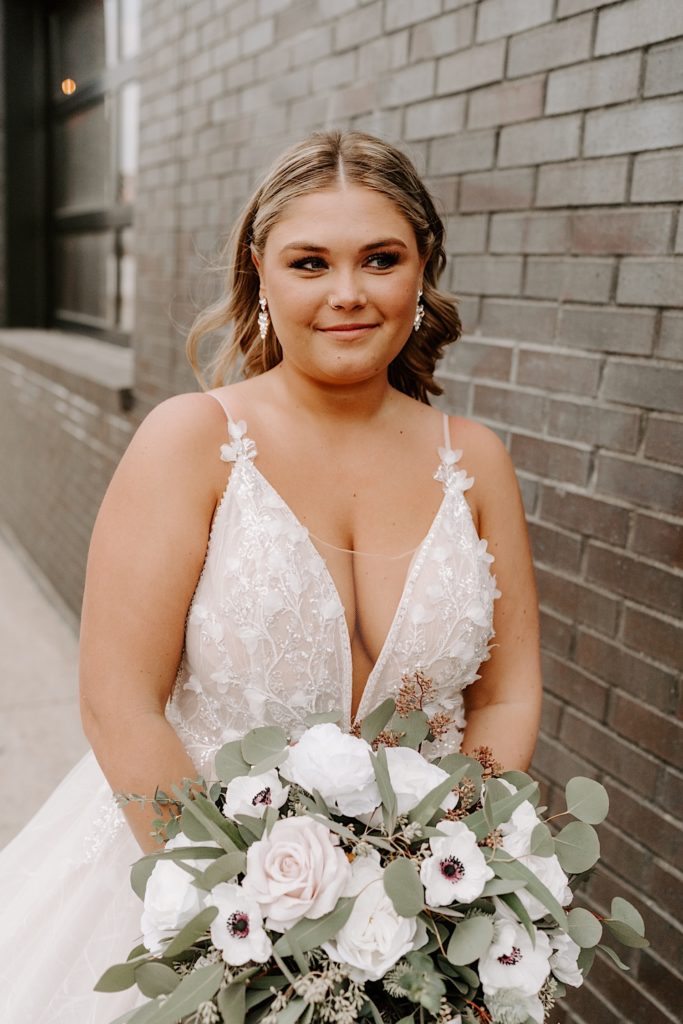 Bride in front of a brick wall outside of wedding venue in downtown Indianapolis