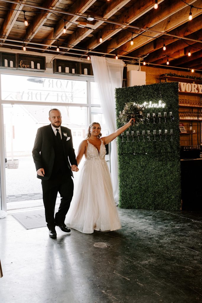 Newlyweds walking into their reception at the Ivory Foundry