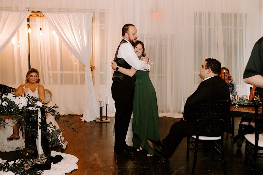 Groom embraces bridesmaid after she gave a speech