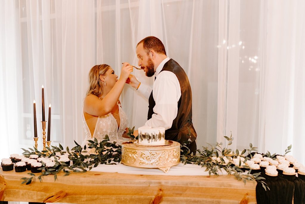 Bride and groom feed each other cake at the Ivory Foundry