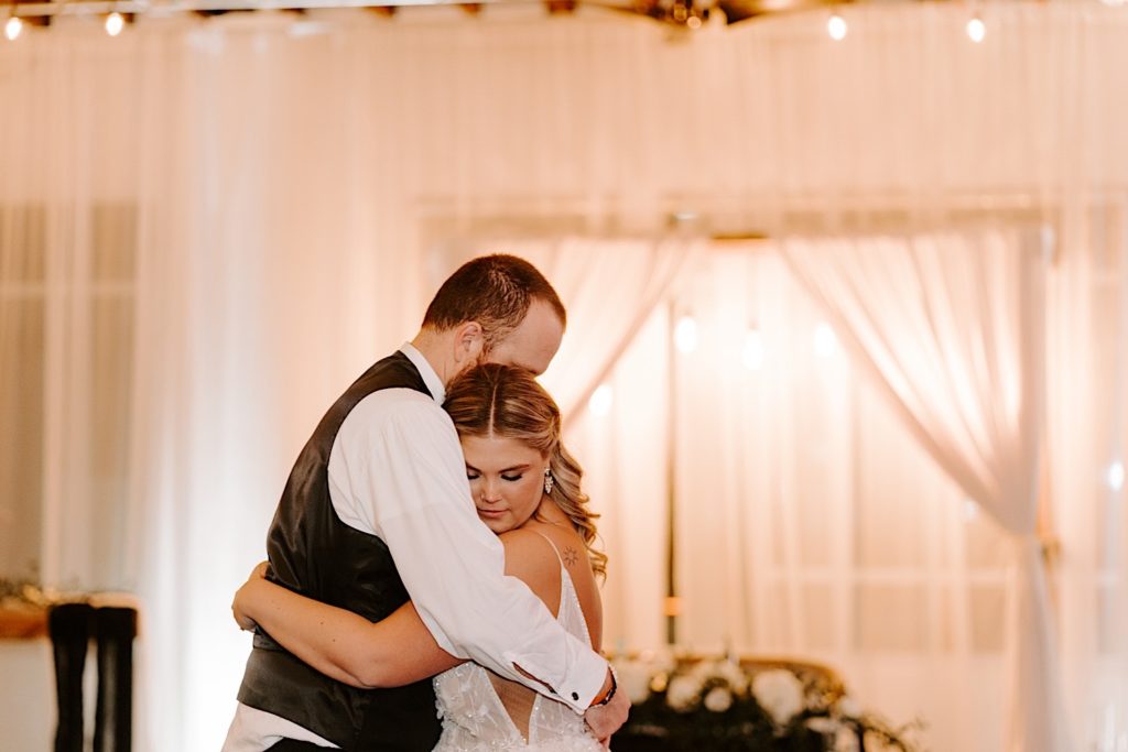 Newlyweds embrace while sharing their first dance at the Ivory Foundry