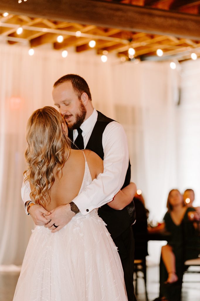 Newlyweds embrace while sharing their first dance at the Ivory Foundry