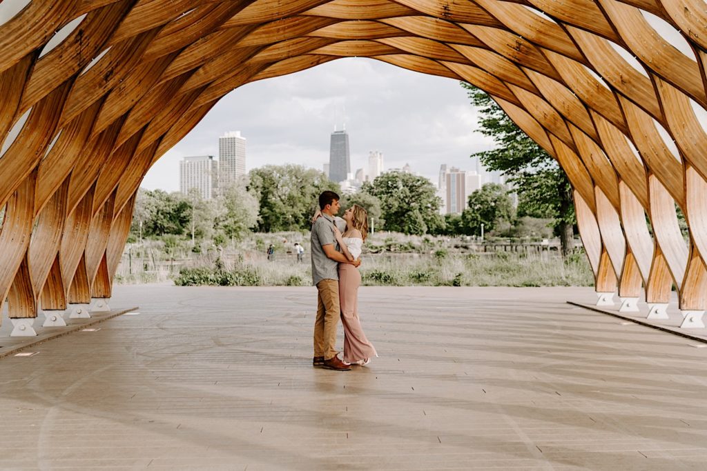 Engaged couple embraces at Lincoln Park Zoo under the beehive