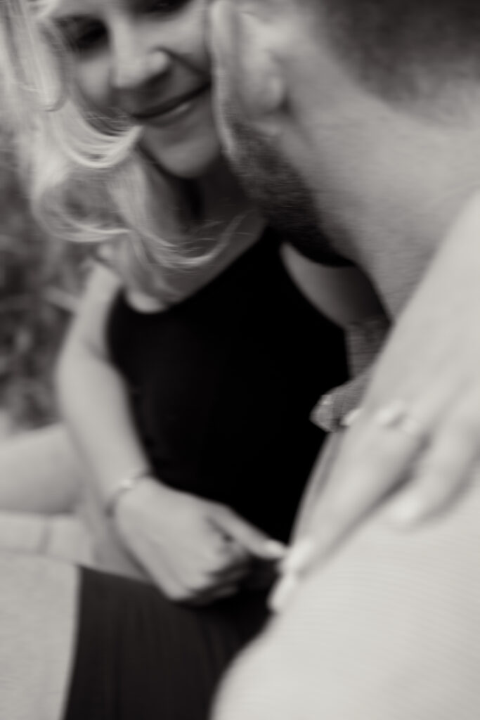 A man kisses his fiancée's cheek during their engagement session at a Chicago brewery