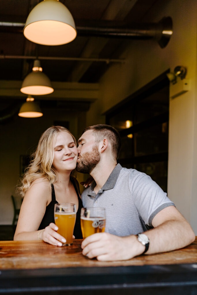 A couple sits and snuggles in a Chicago brewery during their engagement session