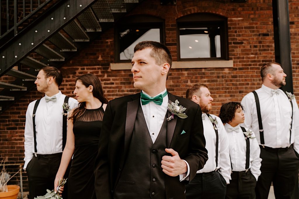 Groom shows off his side profile in front of the wedding party