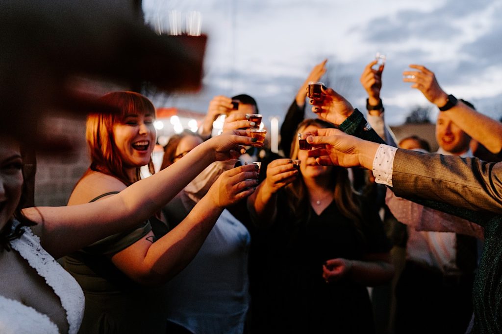 Wedding party takes shot of alcohol at intimate Chicago wedding Venue