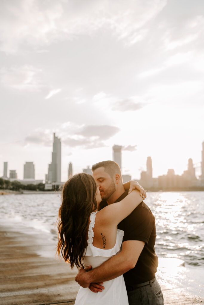 A couple kisses overlooking Lake Michigan at Museum Campus in Chicago.