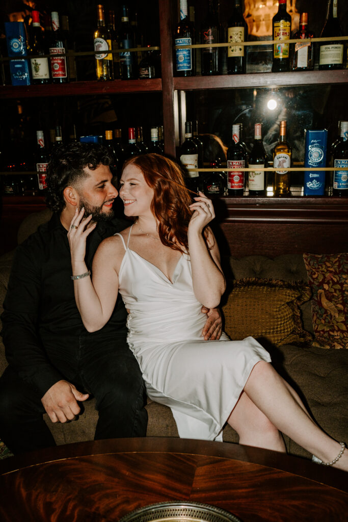 A couple kisses during their engagement session at a bar in Chicago