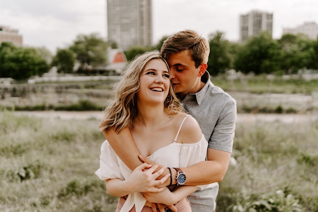 Engaged couple embracing from behind in Chicago engagement session