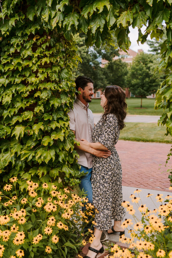 A couple kisses under an arch of flowers and vines at the Lurie gardens in Chicago