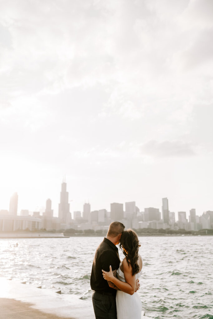 A couple holds one another during sunset overlooking the Chicago skyline.