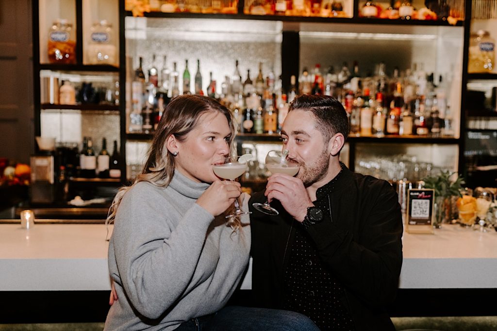 Engaged couple sip on drinks together at bar in Chicago