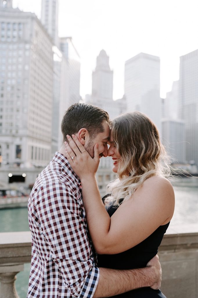 Couple presses their foreheads together during their engagement session on the Riverwalk in Chicago.