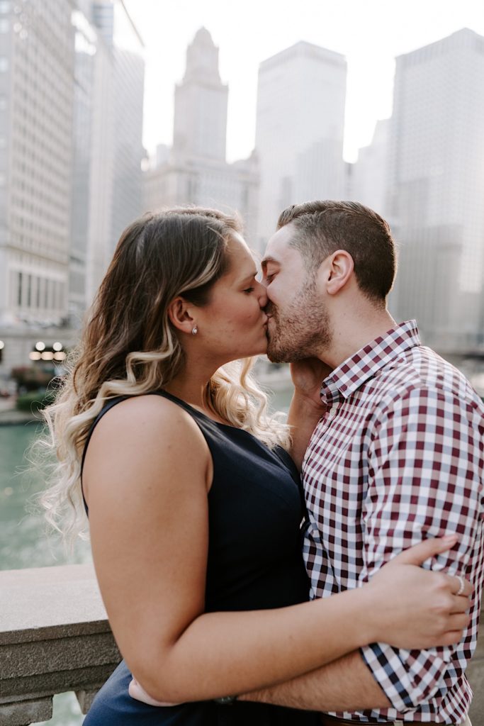 Couple kisses with the Chicago River in the background.
