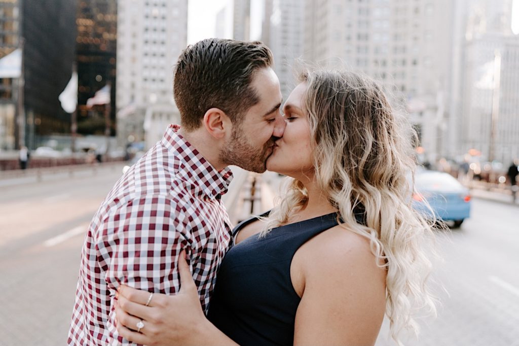 couple kisses in the center of Michigan avenue in Chicago