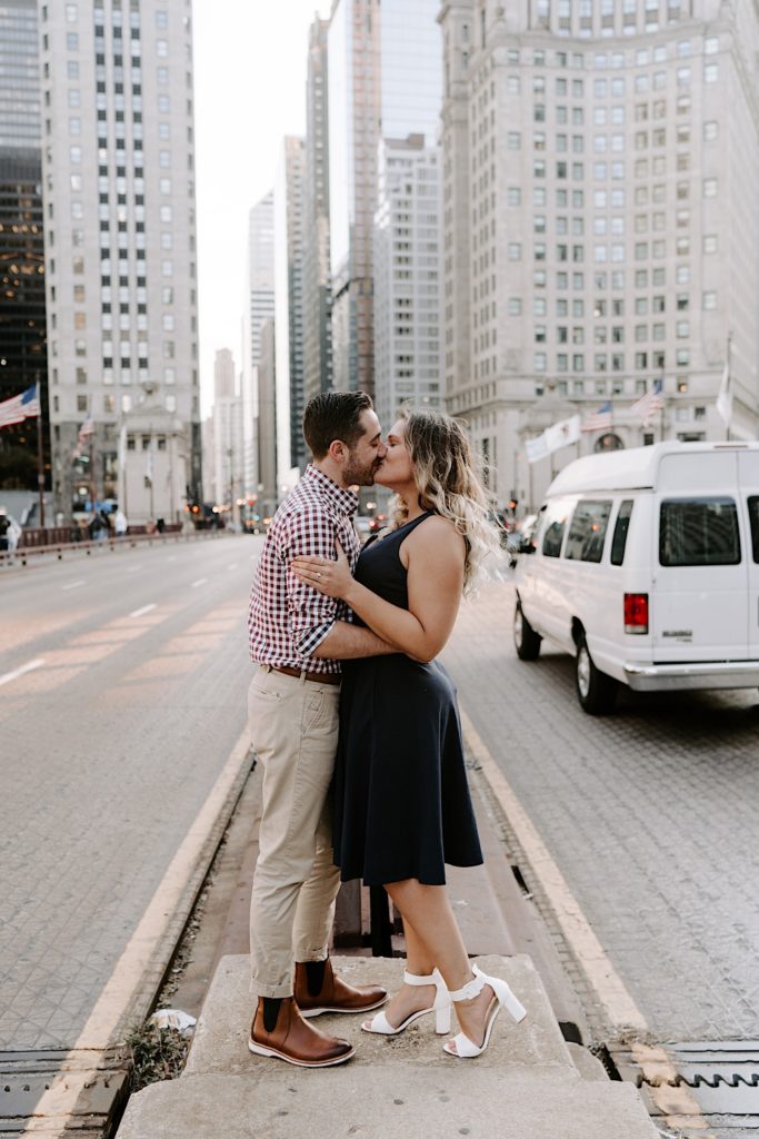 Couple kissing while standing on median on Michigan Avenue in Chicago