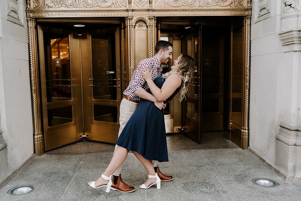 Couple dances in front of Tribune Towers during their Chicago engagement session