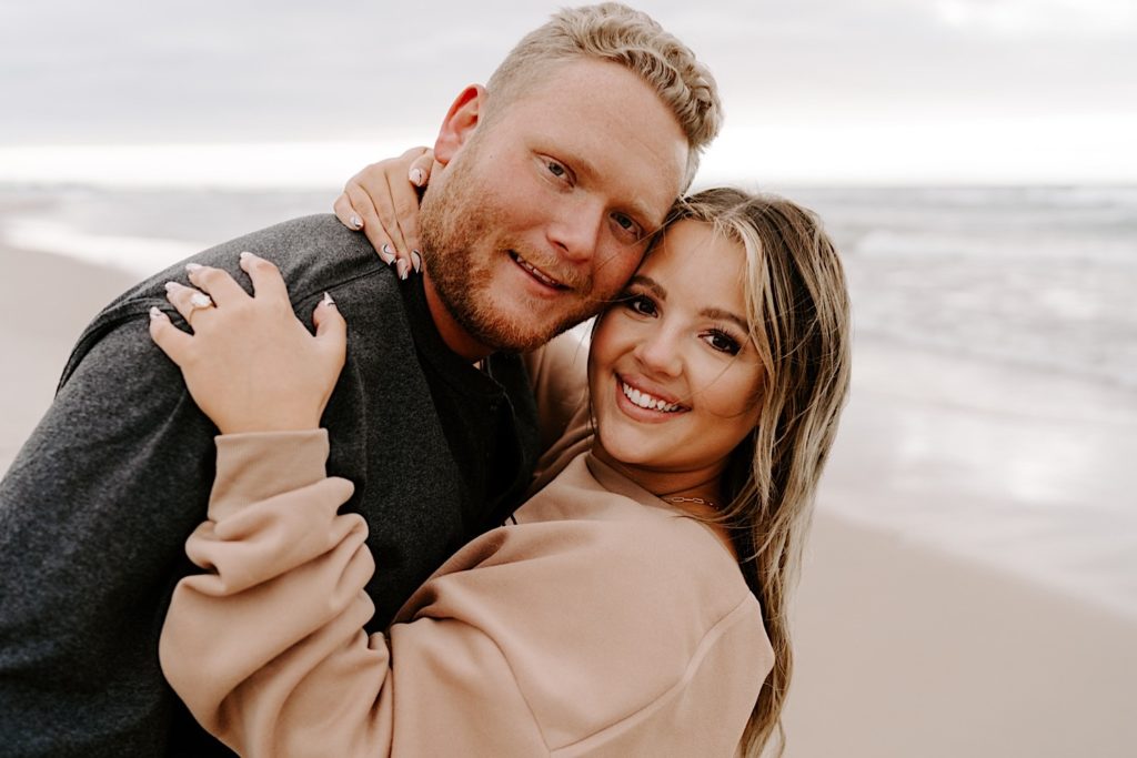 Couple takes engagement photos in their cozy sweatshirts at the Indiana Dunes