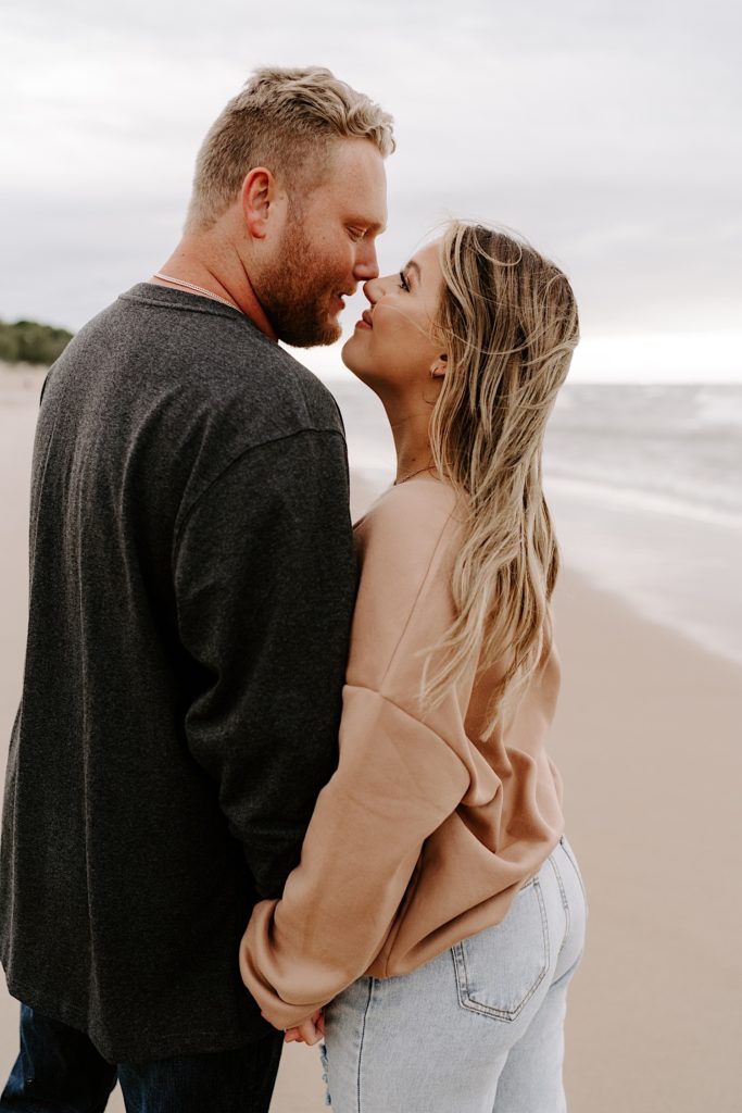 Couple presses their noses together during their engagement session at the Indiana Dunes