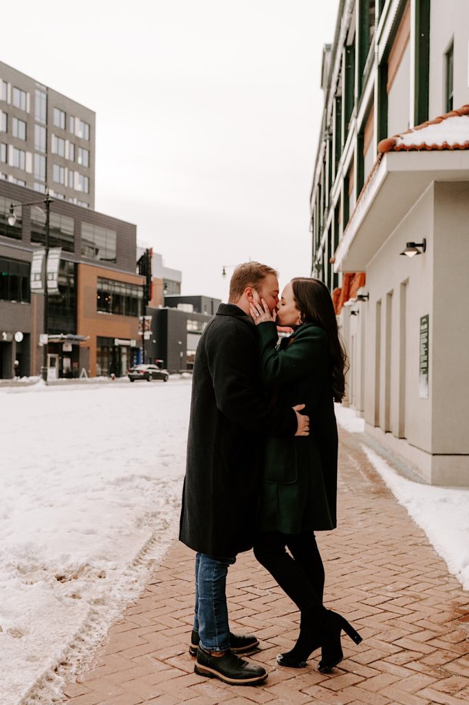Bride and groom stand outside Wrigley Field kissing on a winter day