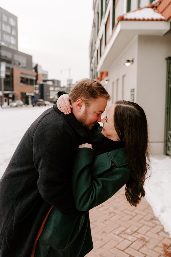 Engaged couple dips while taking their engagement photos outside of Wrigley Field.