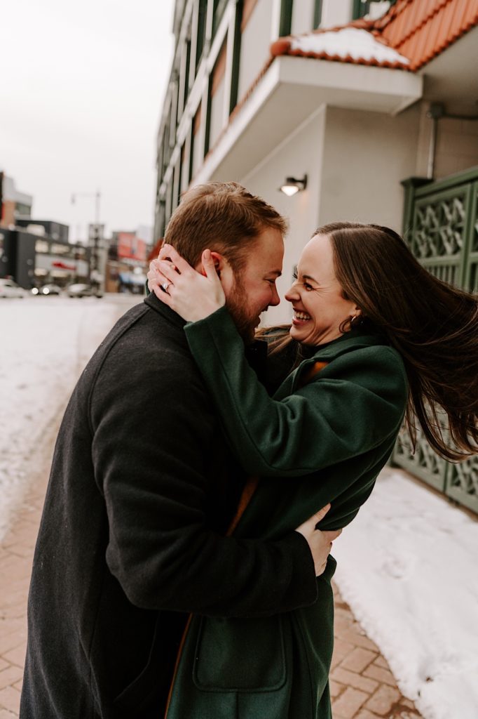 Engaged couple spins while smiling at each other in front of Wrigley Field.