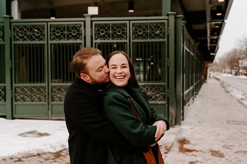 Fiance kisses his future wife standing outside Wrigley Field.