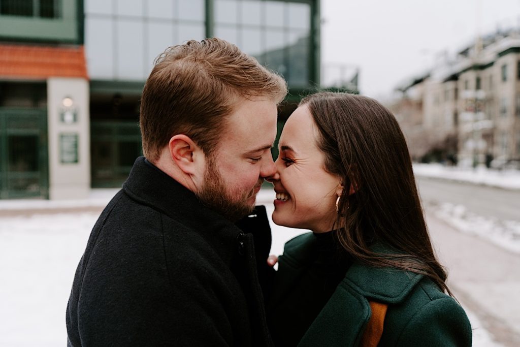Couple almost kisses during their winter engagement session in Wrigleyville.