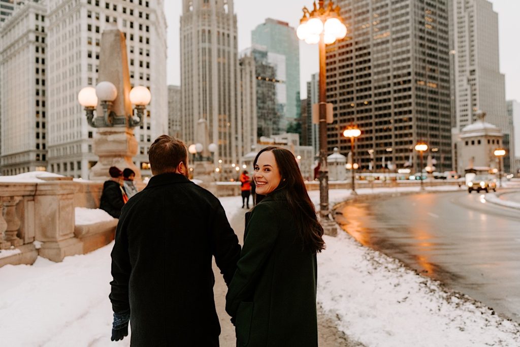 Couple walks along the Chicago Riverwalk as it gets darker during a Chicago winter