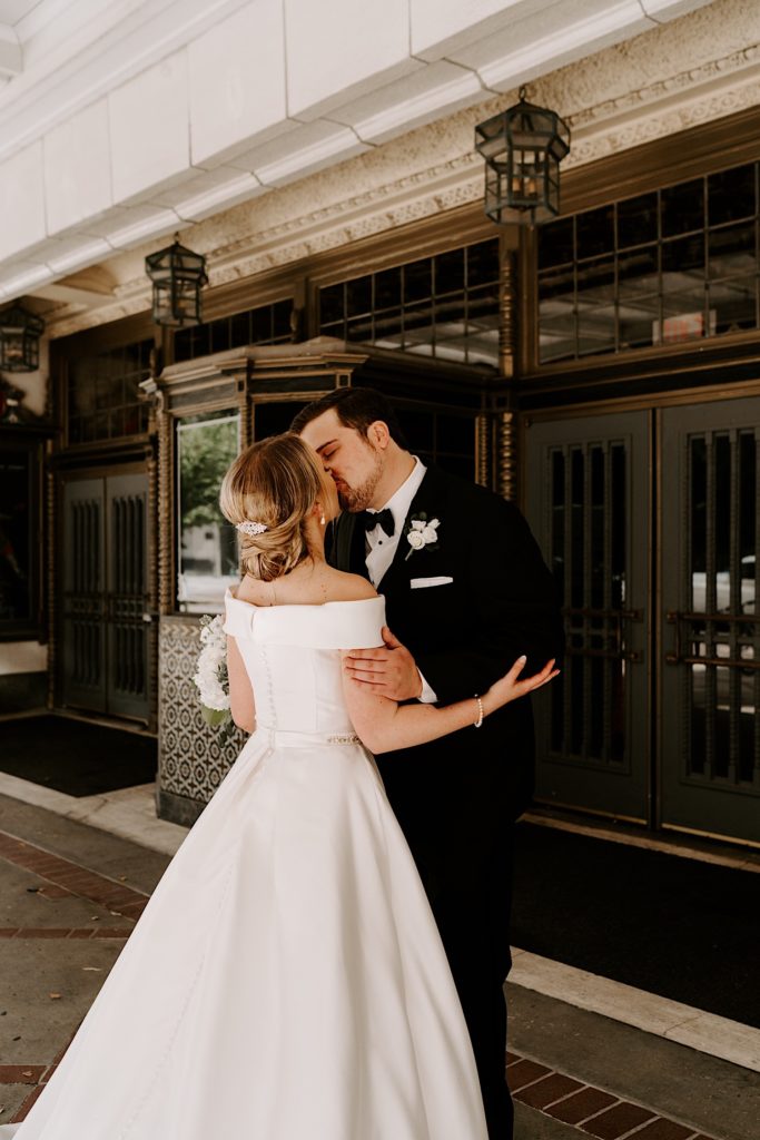 Bride and groom share a kiss during their first look outside the Indiana Repertory Theatre