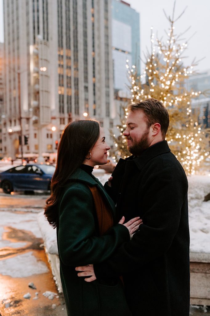 Couple stands next to Michigan Avenue during their winter engagement session.