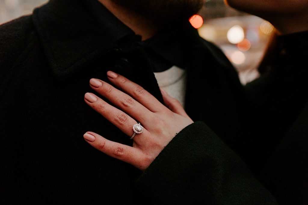 Engaged couple shows off their engagement ring during their winter engagement session in Chicago.