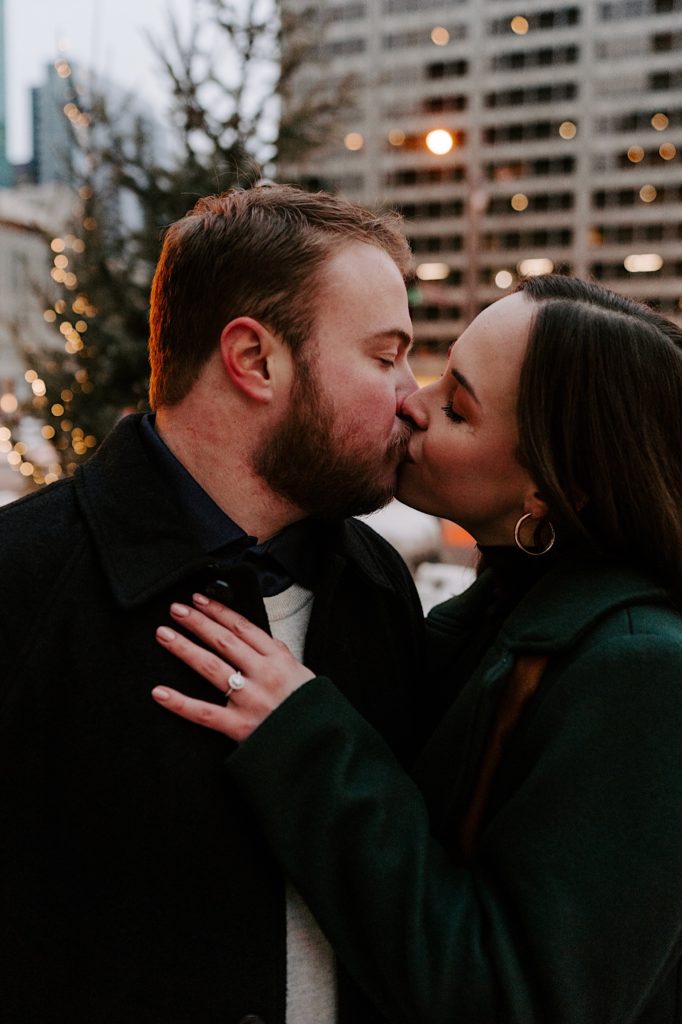 Couple kisses in front of holiday lights on Michigan Avenue in Chicago.